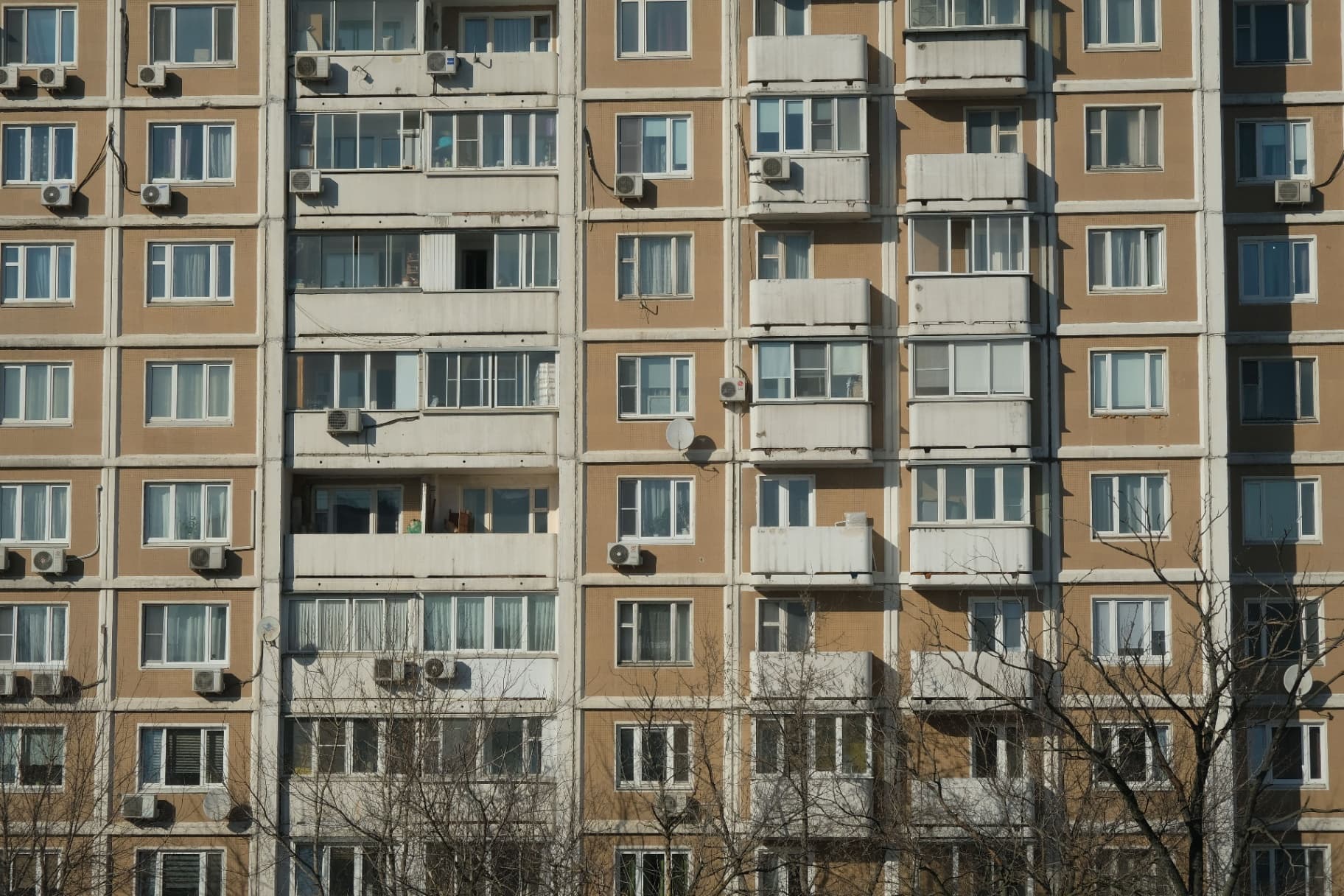 Fasáda panelového bytového domu s mnohými oknami, balkónmi a nainštalovanými klimatizačnými jednotkami - German Engelgardt / Pexels